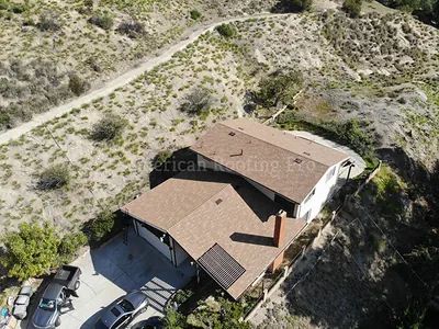 Wide aerial photo of a completed multi slope roof project.